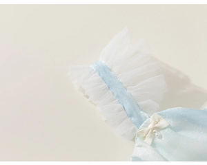 Détail d'une robe bleue pour fille avec manches en tulle blanc, nœud et perles blanches