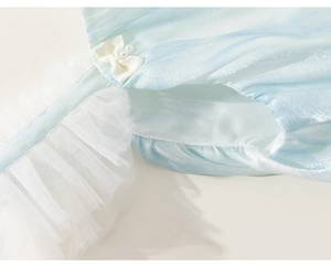 Détail d'une robe en satin bleu clair avec nœud en perles et bordures en tulle blanc