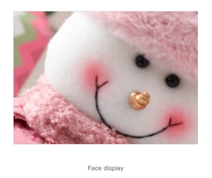 Close-up of pink plush snowman doll face with carrot nose and stitched smile