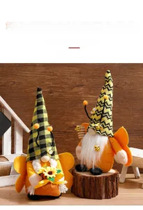 Close-up of yellow bee gnomes with striped hats holding sunflowers and honey stirrers