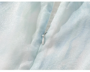 Détail de la fermeture éclair invisible sur tissu pailleté bleu clair pour robe fille