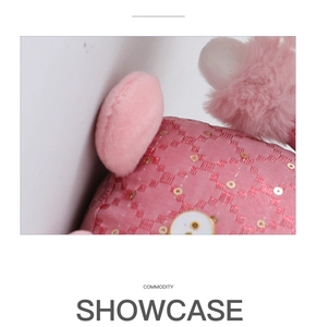 Dettaglio del tessuto con paillettes rosa e bottone bianco sul peluche di Natale