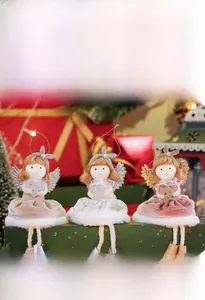 Detailed view of plush Christmas angel dolls with sequin wings on a gift box