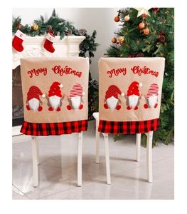 Close-up of Christmas gnome chair covers with Merry Christmas text and buffalo plaid ruffles