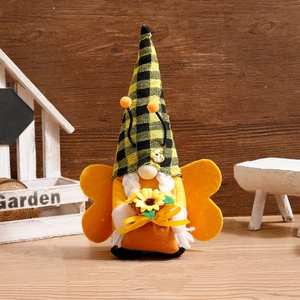 Handcrafted bee gnome plush with sunflower and wings on a rustic wooden garden setting