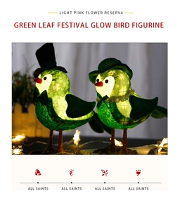 Detail of two glowing green bird figurines with festive hats and warm LED lights