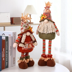 Detail of harvest festival gnome pair with warm orange colors and sunflower decor