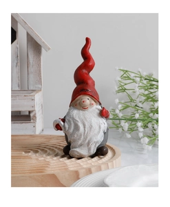 Detail of a Christmas resin gnome figurine with a red hat and glittery white beard