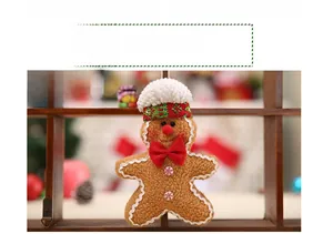 Detail of male gingerbread man plush toy with white hat and red bow tie ornament
