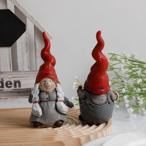 Pair of Christmas gnome figurines with red twisted hats and rustic garden decorations