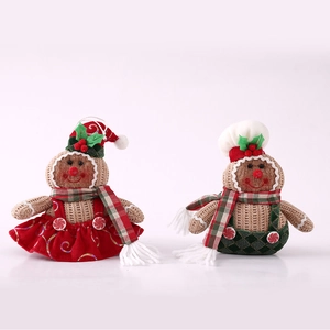Detail view of knitted gingerbread doll ornaments with sequined red skirt and plaid pants