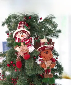 Close-up of plush snowman and reindeer ornaments hanging on a festive Christmas tree