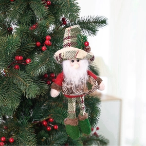 Detail of plush Santa Claus ornament with plaid hat hanging on green Christmas tree branch