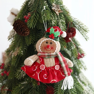 Charming gingerbread girl plush ornament with red sequin dress on a festive Christmas tree