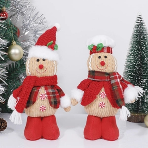 Detailed view of two Christmas gingerbread plush dolls with festive hats and red scarves