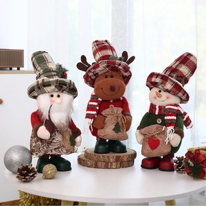 Drei Weihnachtsfiguren mit Weihnachtsmann, Rentier und Schneemann auf einem weißen Tisch