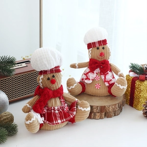 Detail of plush gingerbread man figurines with chef hats and red scarves on wooden stand