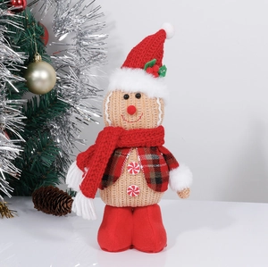Detail view of gingerbread man plush doll with red hat and scarf by Christmas tree