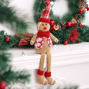 Poupée en peluche bonhomme de pain d'épices de Noël aux longues jambes sur la cheminée