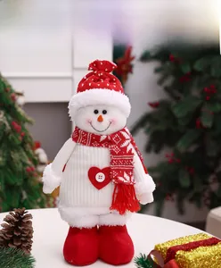 Detailed close-up of a Christmas snowman plush toy with red knit hat and festive heart button