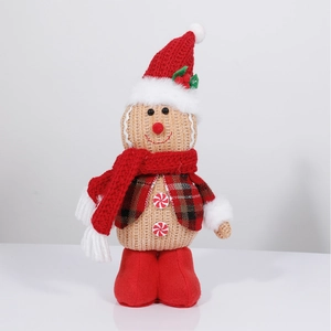 Macro view of gingerbread doll with knit texture, red scarf, and festive holly hat details