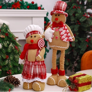 Detailed view of plush gingerbread couple dolls with chef hat and Christmas decor