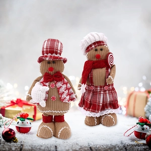 Christmas gingerbread plush doll couple with red plaid hats in snowy holiday setting