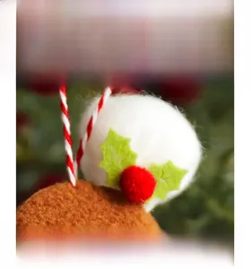 Detail of Christmas gingerbread pendant with plush ball, holly leaves, and red berries