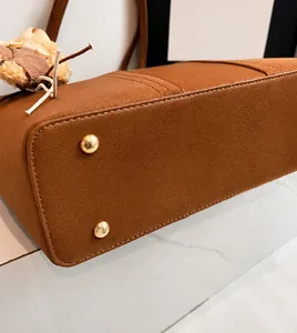Gros plan du fond de sac en cuir marron avec quatre clous de protection en métal doré