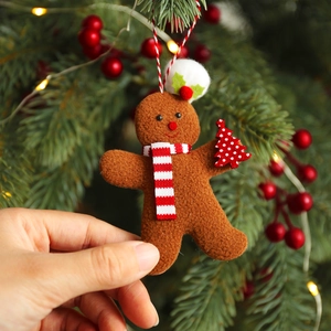 Gingerbread man plush ornament with scarf and hat on a decorated Christmas tree