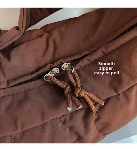 Détail du sac matelassé marron avec fermeture éclair bidirectionnelle et tirettes tissées