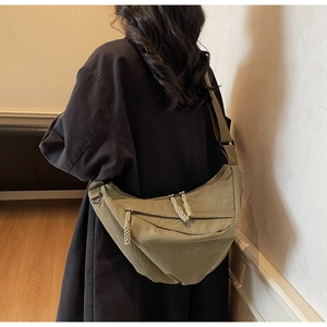 Detalle del bolso bandolera de media luna caqui con correa ancha de nailon ajustable