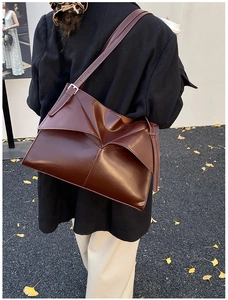 Dettaglio della borsa tote vintage in pelle marrone cioccolato con texture a pieghe e tracolla