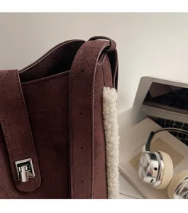 Detail of vintage brown suede bucket bag with faux fur trim and silver buckle
