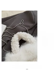 Détail du sac à main en peluche blanche avec bandoulière chaîne argentée et fausse fourrure