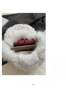 Vue de dessus de l'intérieur du sac en fausse fourrure blanche avec portefeuille et mobile