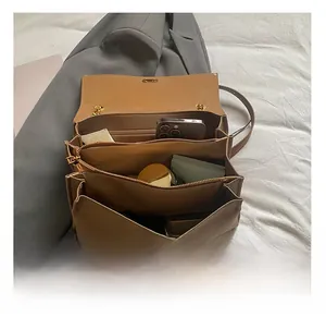 Vista interior del bolso tote de cuero marrón con compartimentos para artículos cotidianos