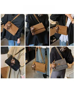 Detalle de bolsos bandolera vintage en marrón y negro con correa de cadena y colgante suave