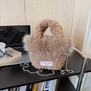 Détail d'un sac à main marron pelucheux avec texture laine d'agneau et chaîne argentée