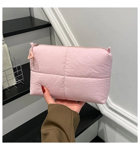 Detail showing pink quilted nylon texture and zipper with triangle puller on handbag