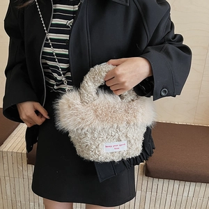Gros plan du sac à main en peluche beige avec étiquette tissée keep your spirit free