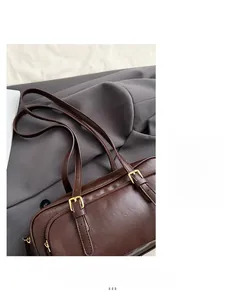 Detail view of the vintage dark brown faux leather shoulder bag with adjustable gold buckle