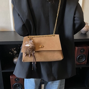 Bolso bandolera vintage marrón con cadena y colgante de monstruo de peluche en modelo