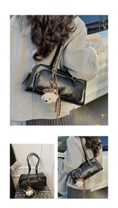 Detail of black leather Boston shoulder bag with gold hardware and plush dog pendant
