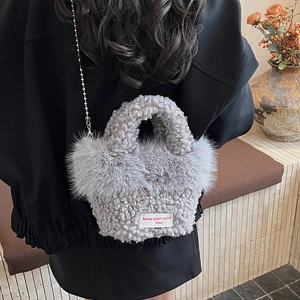 Vue détaillée du sac à main en peluche grise avec bandoulière chaîne sur un mannequin