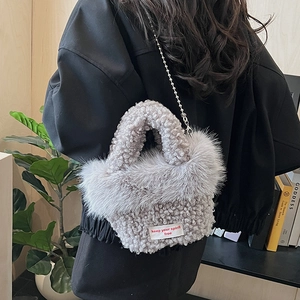 Détail du mini sac en peluche grise avec bandoulière en chaîne et étiquette tissée