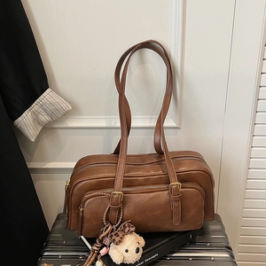 Detail of vintage brown oil wax leather shoulder bag with a cute plush puppy charm