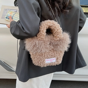 Détail du sac bandoulière en polaire beige avec chaîne en métal et écusson brodé