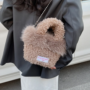 Détail du sac seau en peluche kaki avec bandoulière chaîne argentée et étiquette