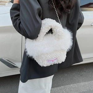 Détail d'un sac à main blanc en fausse fourrure avec bandoulière et étiquette tissée